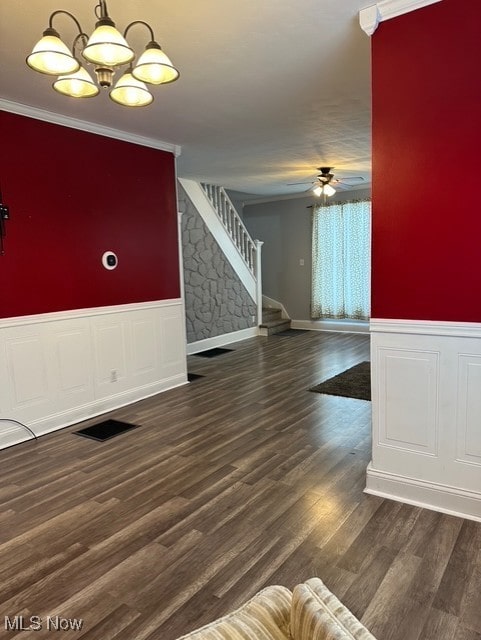 interior space featuring crown molding, dark wood-type flooring, and ceiling fan with notable chandelier