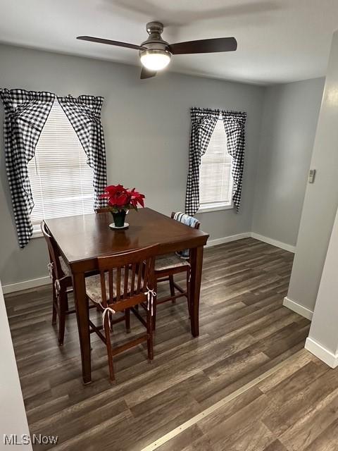 dining room with ceiling fan and dark wood-type flooring