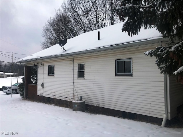 view of snow covered exterior with central AC