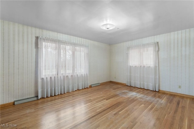 spare room with wood-type flooring and a baseboard radiator