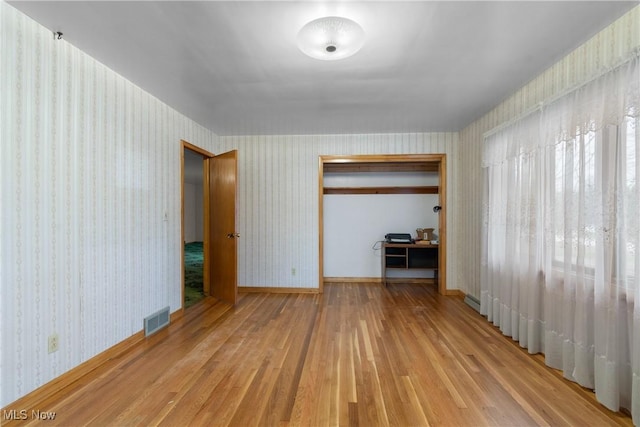 unfurnished bedroom featuring wood-type flooring and a closet