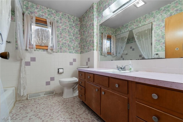 full bathroom with vanity, shower / bath combo, tile patterned flooring, toilet, and tile walls