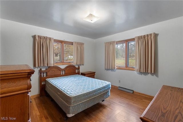 bedroom featuring wood-type flooring and baseboard heating