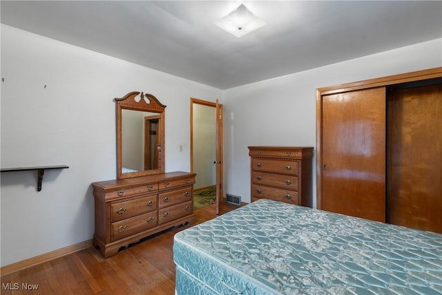 bedroom with wood-type flooring and a closet