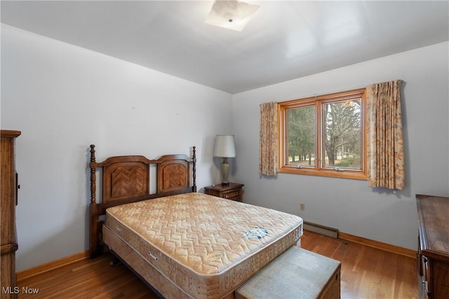 bedroom featuring a baseboard radiator and light hardwood / wood-style flooring