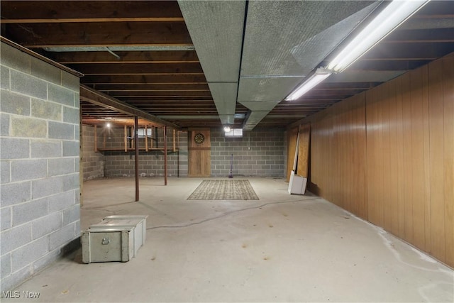 basement featuring wooden walls