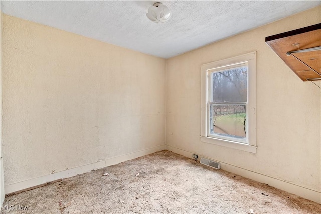 carpeted spare room featuring a textured ceiling