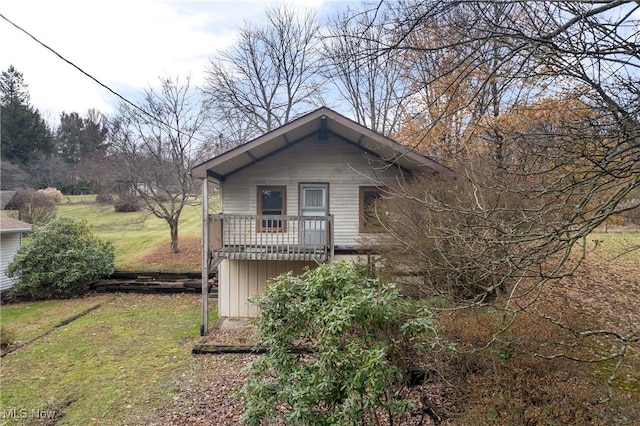 view of side of home featuring a balcony and a lawn