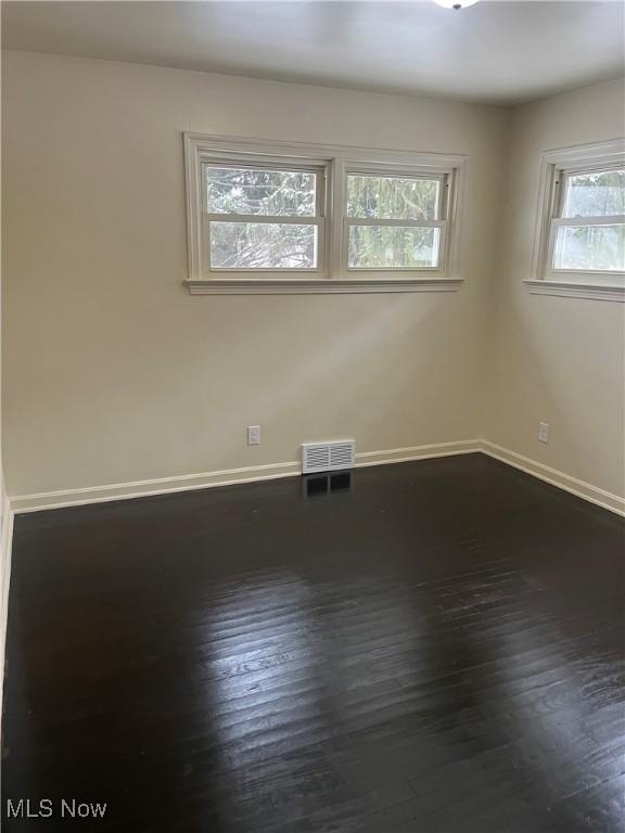 empty room with dark wood-type flooring