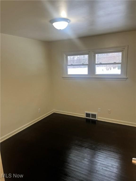 spare room with dark hardwood / wood-style floors