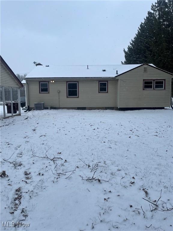 snow covered back of property with central AC unit