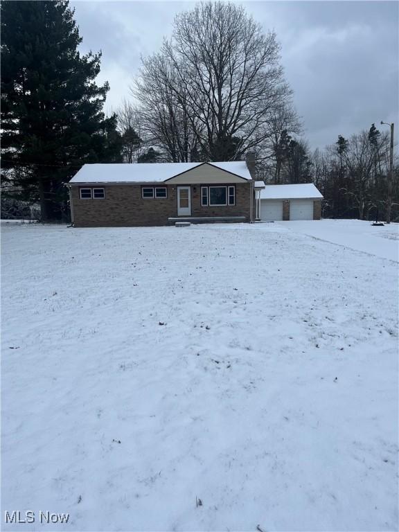 view of front of home with a garage and an outbuilding