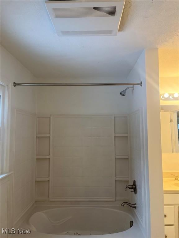 bathroom featuring vanity and  shower combination