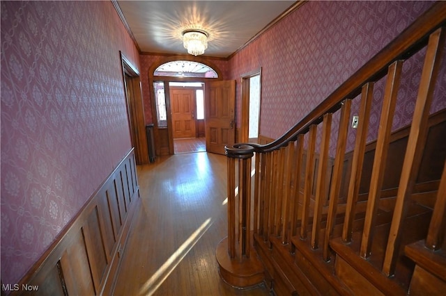 foyer entrance with hardwood / wood-style flooring and crown molding