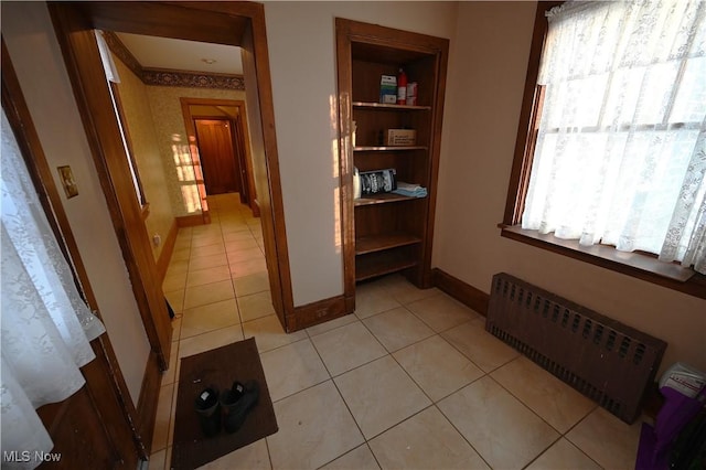 hall featuring radiator heating unit and light tile patterned flooring