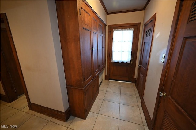 doorway to outside with light tile patterned floors and crown molding