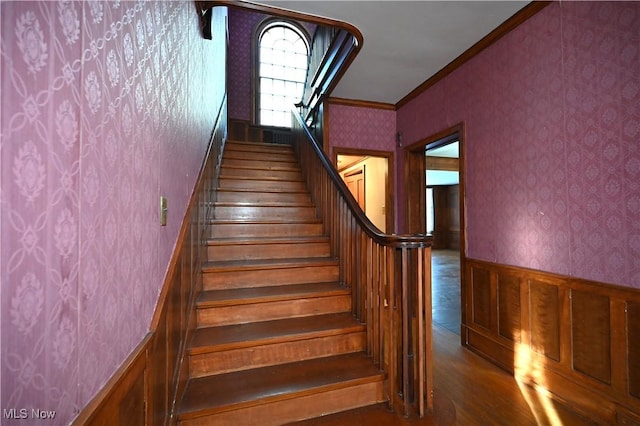 staircase featuring hardwood / wood-style flooring and ornamental molding