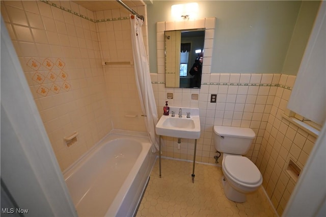 full bathroom featuring shower / tub combo with curtain, sink, tile walls, tile patterned flooring, and toilet