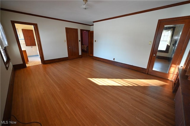 empty room featuring light wood-type flooring and crown molding