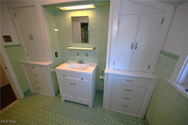 bathroom featuring vanity and tile walls