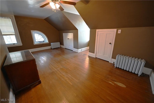 bonus room with radiator heating unit, hardwood / wood-style floors, and lofted ceiling