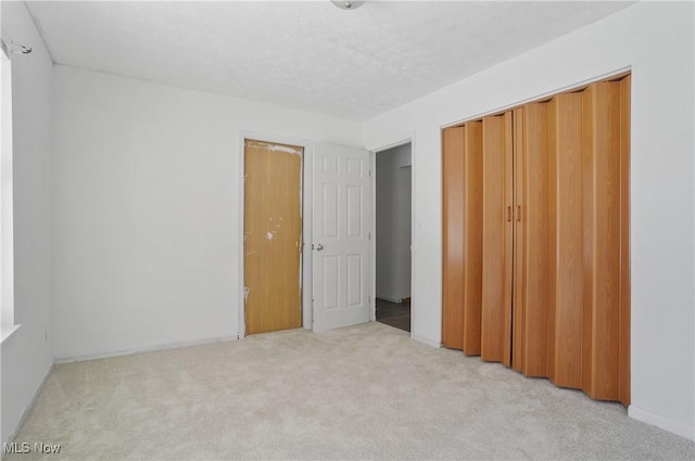 unfurnished bedroom featuring light colored carpet and a closet