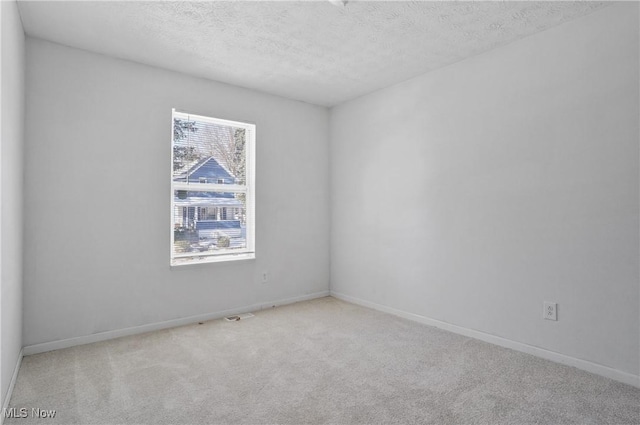 carpeted empty room with a healthy amount of sunlight and a textured ceiling