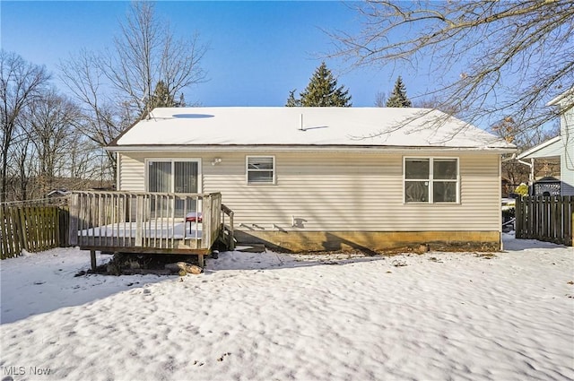 snow covered house featuring a wooden deck