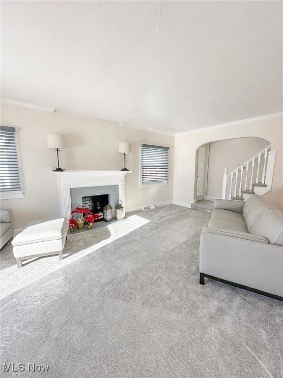 living room with light colored carpet and ornamental molding