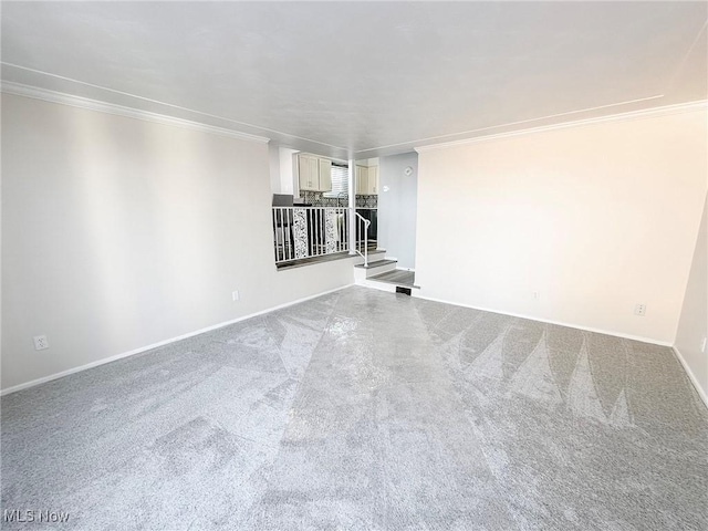 unfurnished living room featuring carpet and crown molding