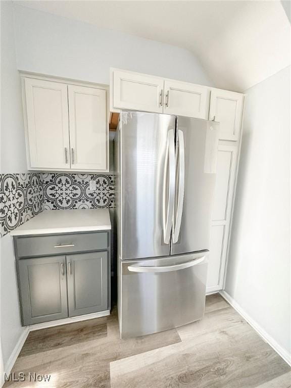 kitchen with stainless steel refrigerator, white cabinetry, gray cabinetry, and light wood-type flooring