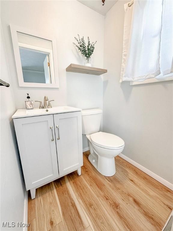 bathroom featuring hardwood / wood-style flooring, vanity, and toilet