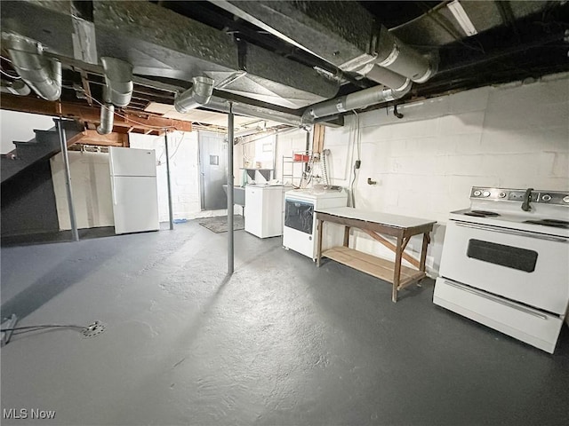 basement featuring washer and dryer and white fridge