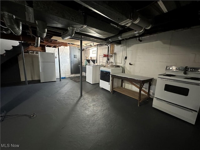 basement with stainless steel refrigerator and independent washer and dryer