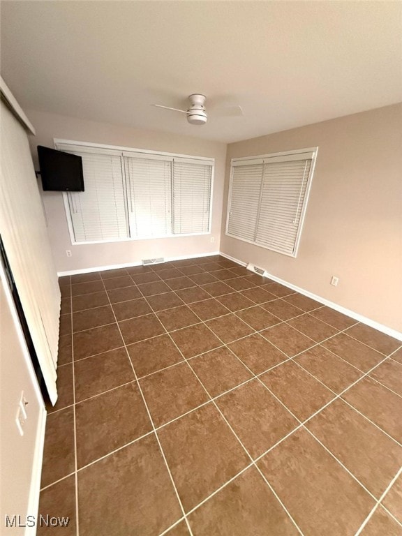 tiled empty room with ceiling fan