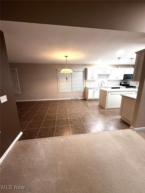 kitchen featuring pendant lighting, sink, tile patterned flooring, white cabinetry, and stainless steel appliances