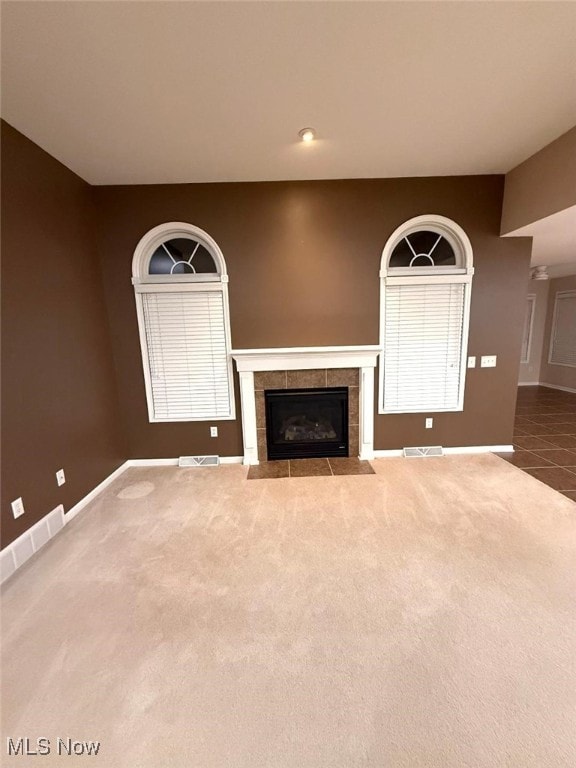 unfurnished living room featuring a fireplace and carpet