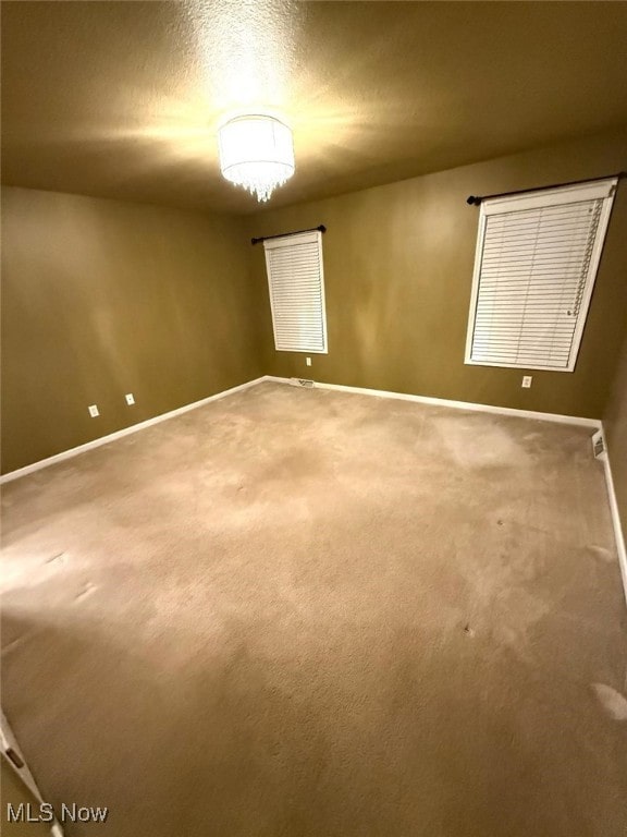 unfurnished room with carpet and a textured ceiling