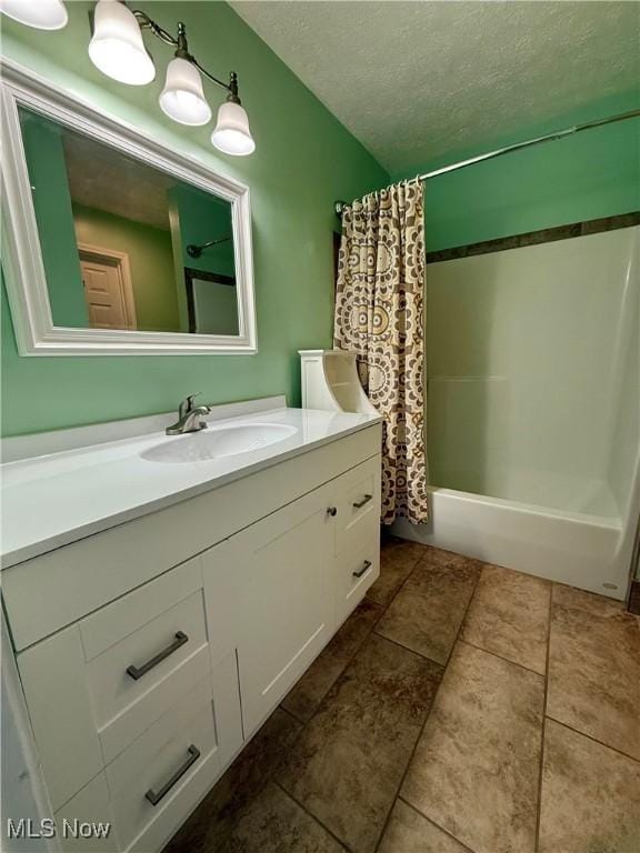 bathroom with shower / tub combo, vanity, and a textured ceiling