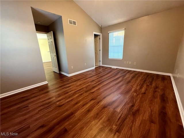 unfurnished room featuring vaulted ceiling and dark wood-type flooring