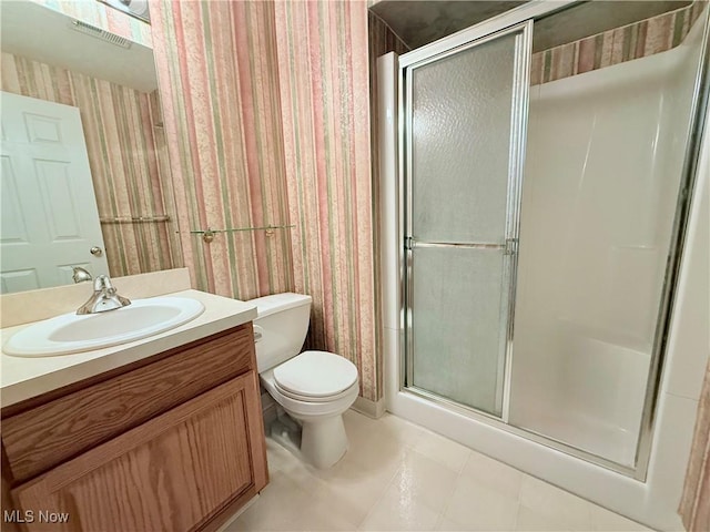 bathroom with walk in shower, vanity, and toilet