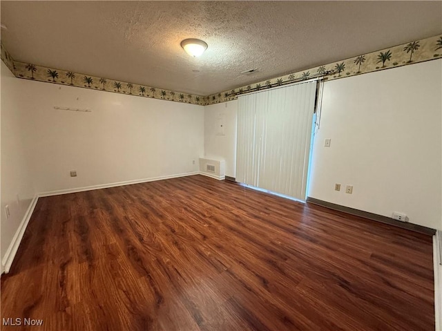 empty room featuring a textured ceiling and hardwood / wood-style flooring