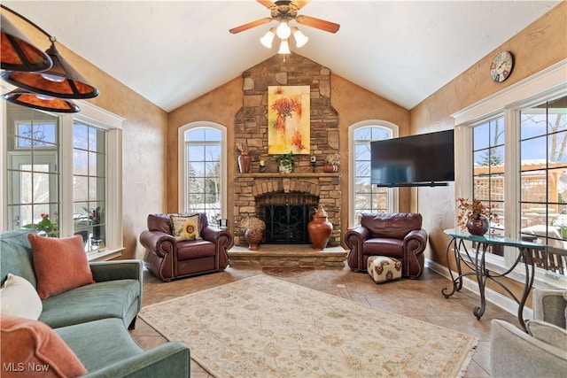 living room featuring a stone fireplace, ceiling fan, light tile patterned floors, and vaulted ceiling