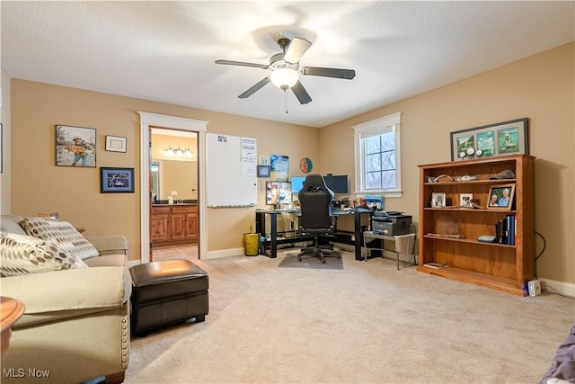 carpeted office featuring a textured ceiling and ceiling fan