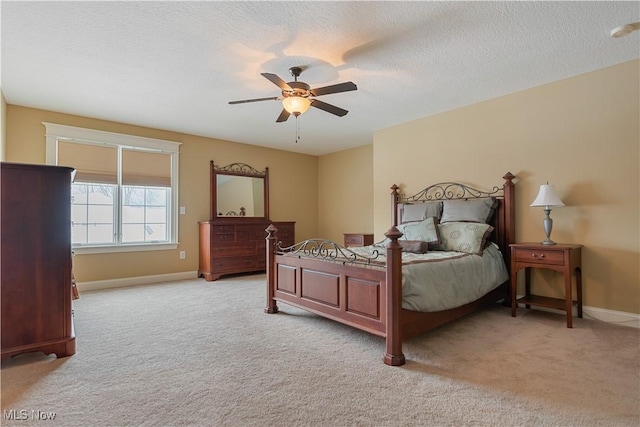 bedroom featuring ceiling fan, light colored carpet, and a textured ceiling