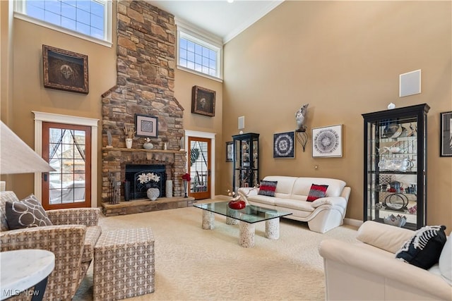 living room with carpet, crown molding, a towering ceiling, and a fireplace