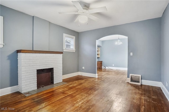 unfurnished living room featuring a fireplace, wood-type flooring, and ceiling fan