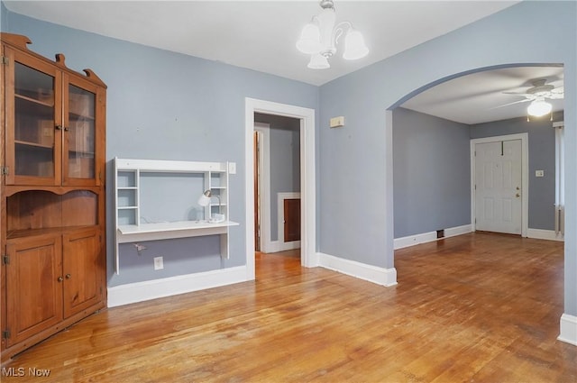 unfurnished living room with light hardwood / wood-style floors and ceiling fan with notable chandelier