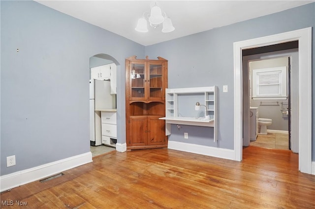 unfurnished living room with light hardwood / wood-style floors and an inviting chandelier