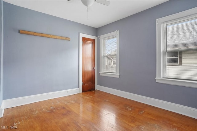 spare room featuring hardwood / wood-style flooring, ceiling fan, and a healthy amount of sunlight